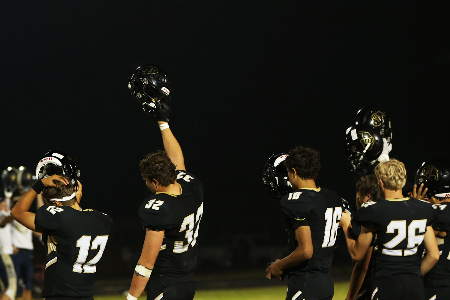 Buffalo High School athletes lift their helmets to wave thank you